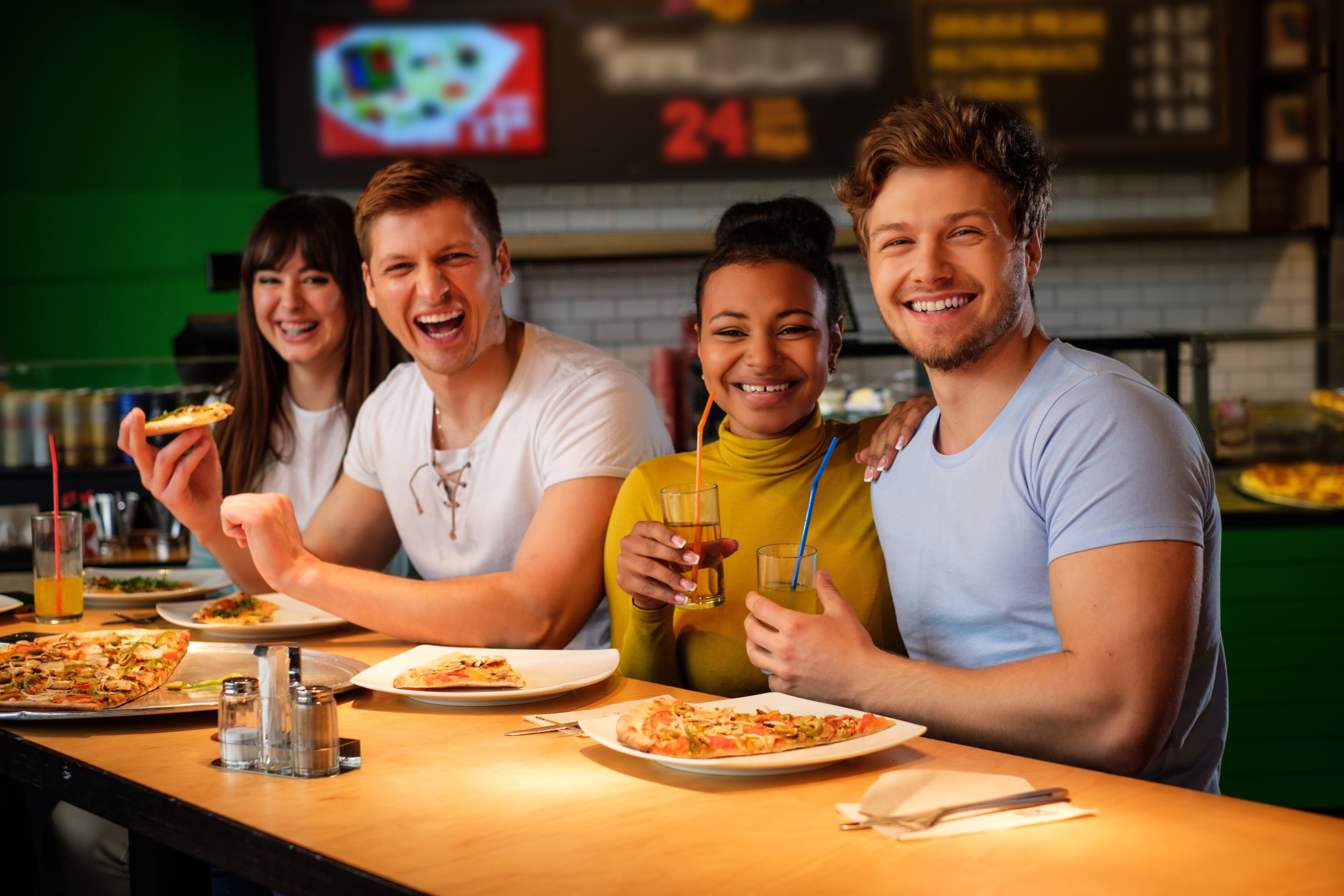 Group of friends enjoying pizza at restaurant