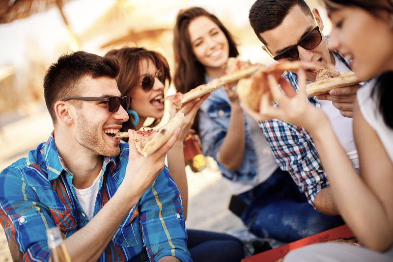 Friends enjoying pizza outdoors